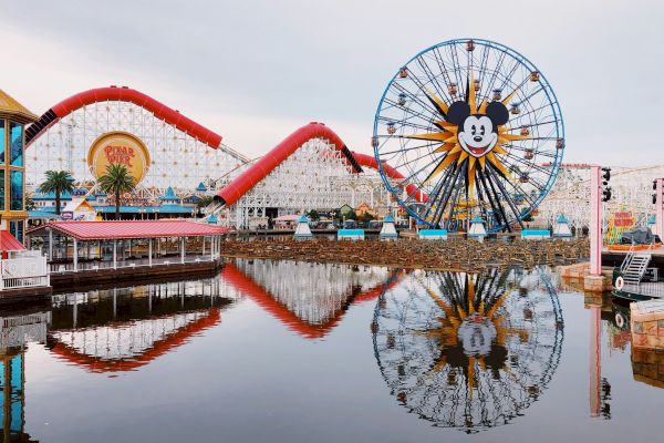 A playful amusement park scene with a playful roller coaster track looping over a float, bright colors, and a Ferris wheel in the background.